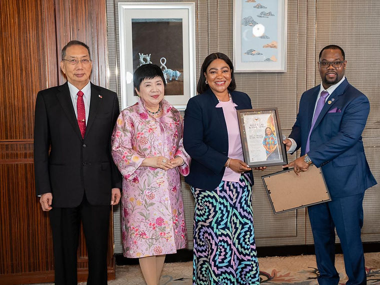 Four delegates standing together during the presentation of a framed Certificate of Appreciation