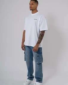 Full-body studio portrait of a male model in a white t-shirt and blue denim cargo pants