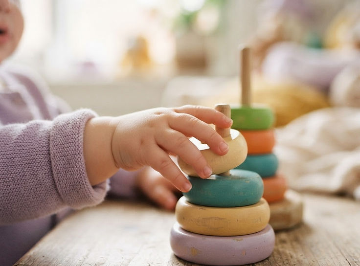 A child's hand reaching for a colorful toy