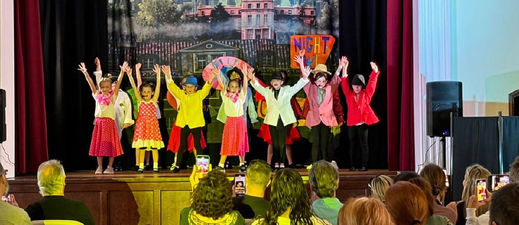 Full Showstoppers cast in a final showstopper pose on stage