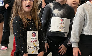 Camper wearing a Team Zoey badge during a Showstoppers rehearsal