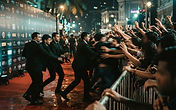 Crowded red carpet premiere at night with steel barricades and security moving toward a breach, illustrating fan boundaries and celebrity protection after the Wicked: For Good Singapore premiere