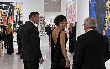 Event security agent accompanying guests through an art gallery during a Miami exhibition
