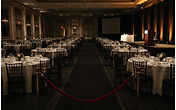 Illustration of a black-tie banquet ballroom with a lectern and a velvet rope line. Editorial illustration, not a photograph of the Washington Hilton.