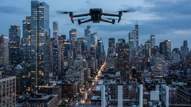 Illustration of a small quadcopter drone hovering above a city rooftop at dusk with a radar dome and antenna array below it