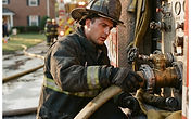 Firefighter in turnout gear at a residential fire scene, symbolic editorial photograph for USPA Nationwide Security news coverage