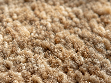 Detalhe aproximado da textura das fibras do carpete em tons de areia
