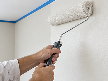 Aplicação de tinta com rolo em parede interna, com fita de proteção no teto