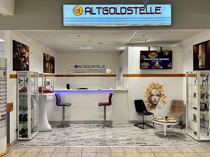 Die Altgoldstelle von vorn: Theke mit Barhockern, Vitrinen, Bildschirm und Warteecke unter dem beleuchteten Schild
