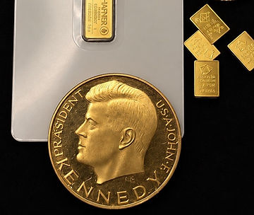 Goldmedaille, kleine Goldbarren und ein 1-Gramm-Barren in der Blisterkarte