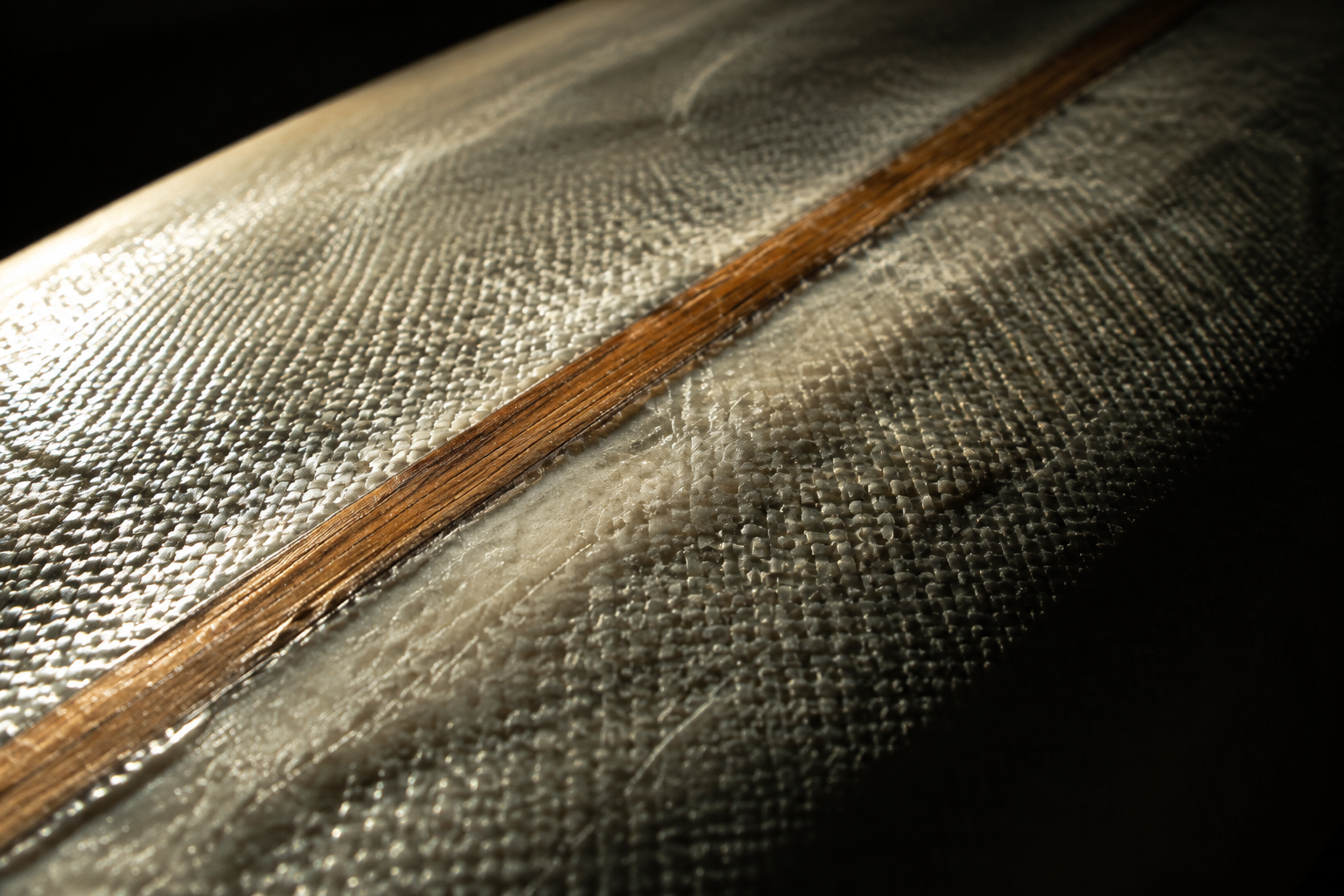 Macro view of fibreglass weave and a cedar stringer under clear resin