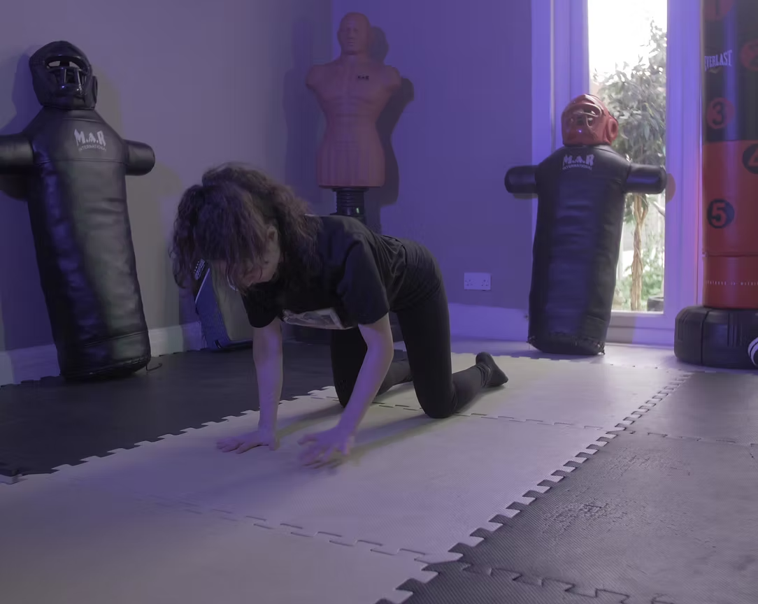 A member practising ground self-defence around training pads