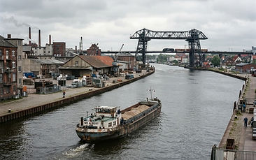 Gewerbebauten in Rendsburg mit Kanal und Hochbrücke im Hintergrund