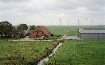 Schleswig-Holsteinische Landschaft mit Gewerbebau, Photovoltaikfläche und Windrädern