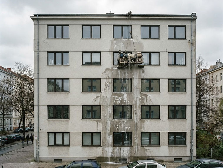 Reinigungsdrohne reinigt die helle Fassade eines modernen Gewerbegebäudes