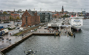 Glasfassade eines Bürogebäudes am Kieler Hafen mit Reinigungsdrohne davor