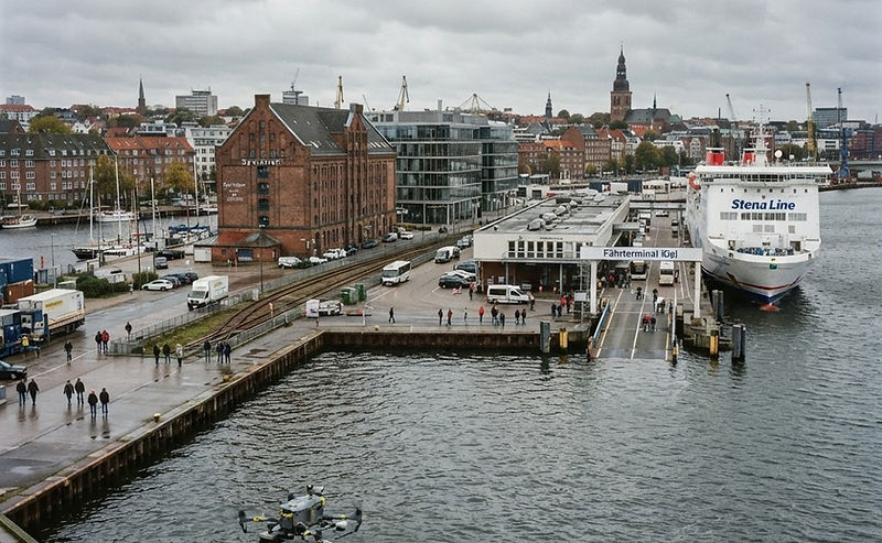 Glasfassade eines Bürogebäudes am Kieler Hafen mit Reinigungsdrohne davor