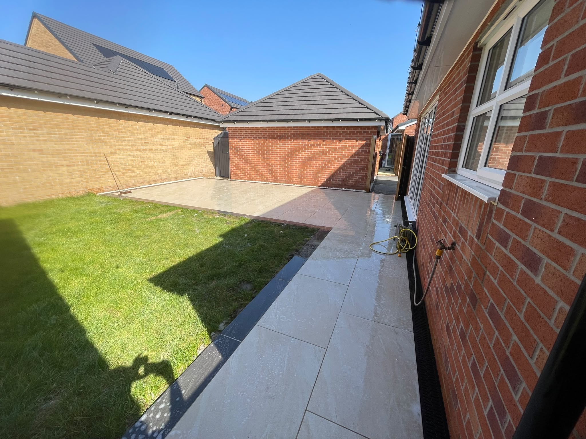 Porcelain patio wrapping the rear garden