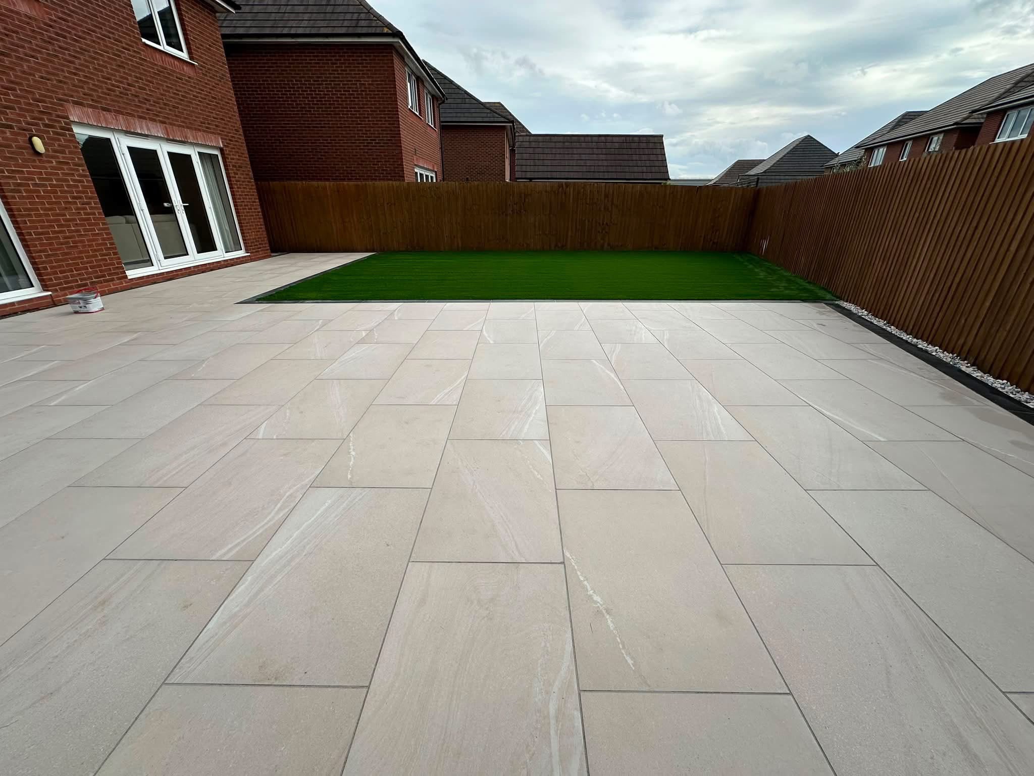 Stone patio with new lawn and slatted fencing