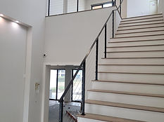 Foyer stair and landing guardrail in black steel. Stairs by RF Iron Works
