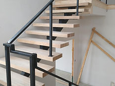 Floating stair and landing with square-bar steel railing. Stairs by RF Iron Works