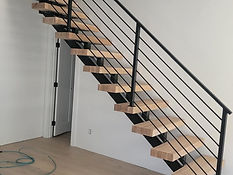 Wall-hung open-riser steel stair. Stairs by RF Iron Works