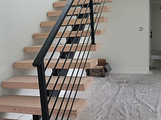 Floating mono-stringer steel stair with bar railing. Stairs by RF Iron Works