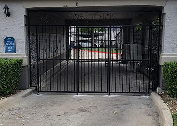 Large decorative iron gate at a commercial driveway