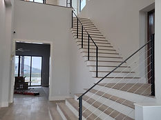 Two-story foyer stair with horizontal bar railing. Stairs by RF Iron Works