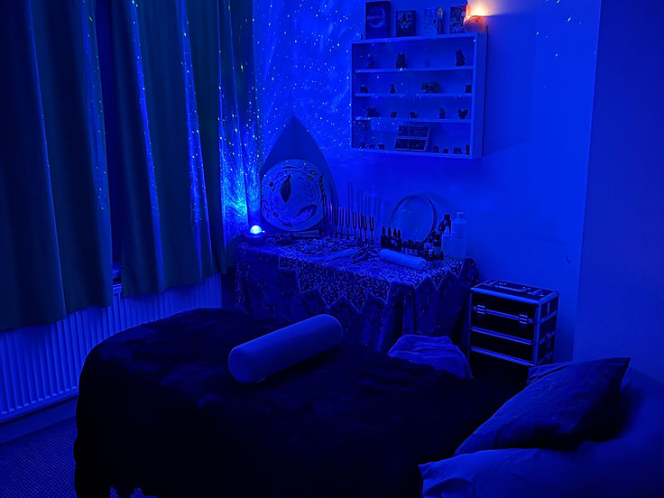 The Purple Clouds Holistics treatment room in Eccleston, lit in deep blue with a starry ceiling effect