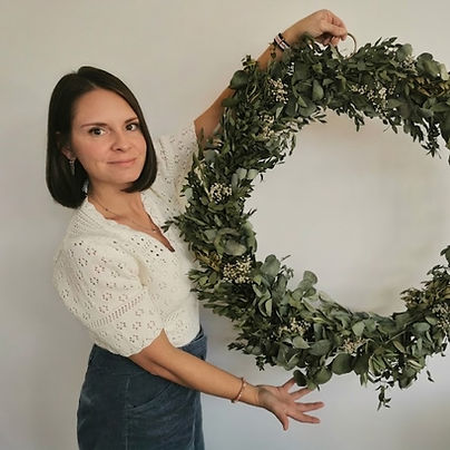 Christel, artisane fleuriste, avec une couronne d'eucalyptus