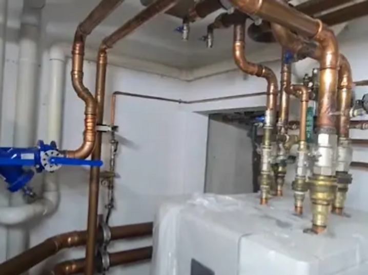 Copper pipework manifold connected to a boiler, with brass fittings and isolator valves