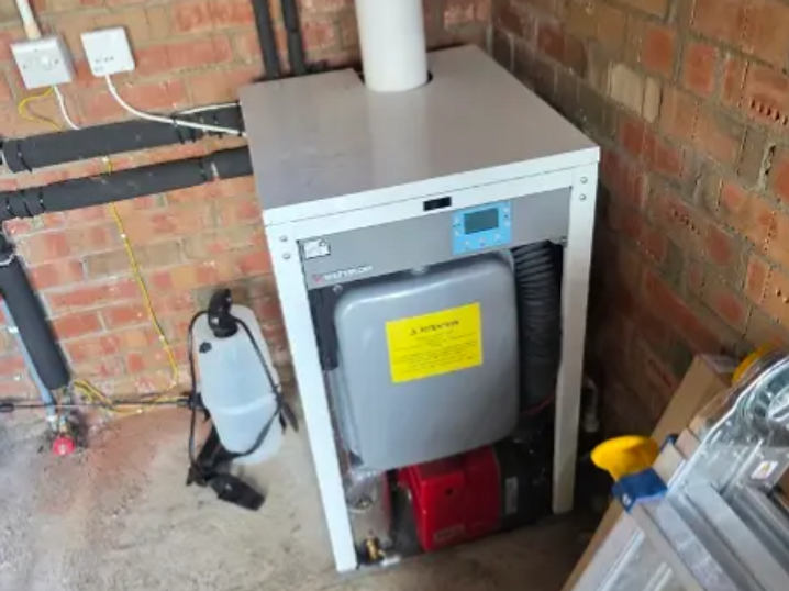 Floor-standing boiler installed against brickwork with its flue and pipework