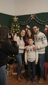 Familia posando frente al árbol de navidad en el marco de fotos del bazar