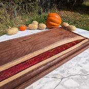 Walnut river board — deep red resin with gold leaf.