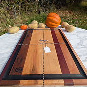 Segmented walnut board with the Masterworks crest in the corner.