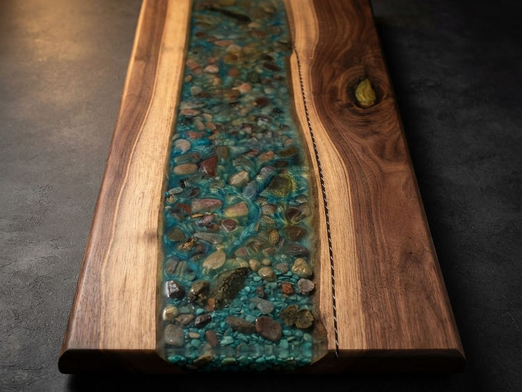 A live edge river board with stone set through the pour.