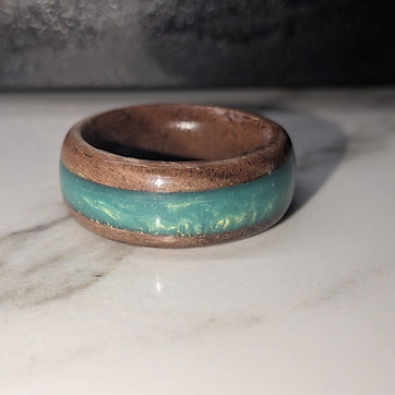 A mica-green inlay in a dark band, shot on marble.