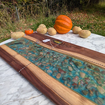 Live edge river board with stone set into the pour.