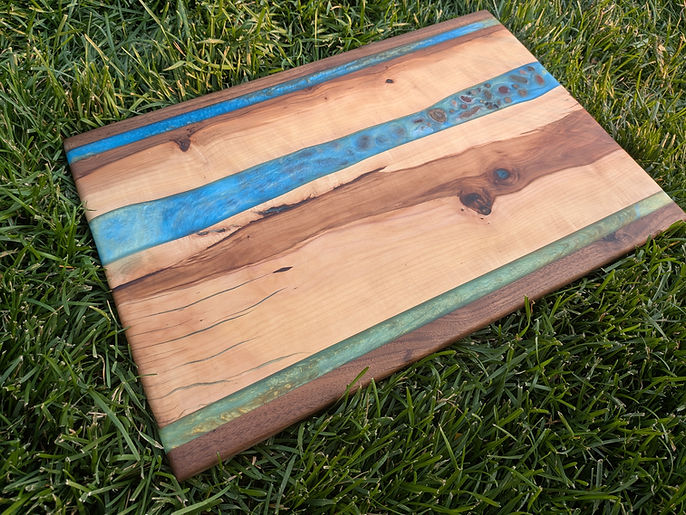 A cherry board with blue and sage green resin rivers