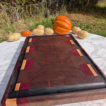 Multi-species board — walnut field with maple and purpleheart.