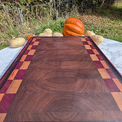 End grain board — walnut arches framed in maple and purpleheart.