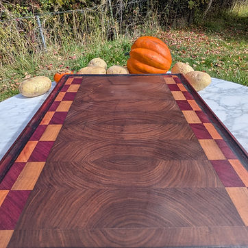 End grain board — walnut arches framed in maple and purpleheart.