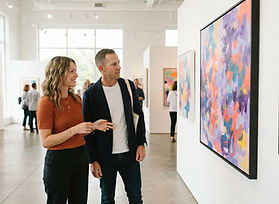 Two people viewing an exhibition in a bright gallery