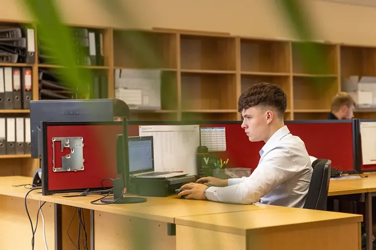 A person working at a monitor in a workshop (stock photograph)