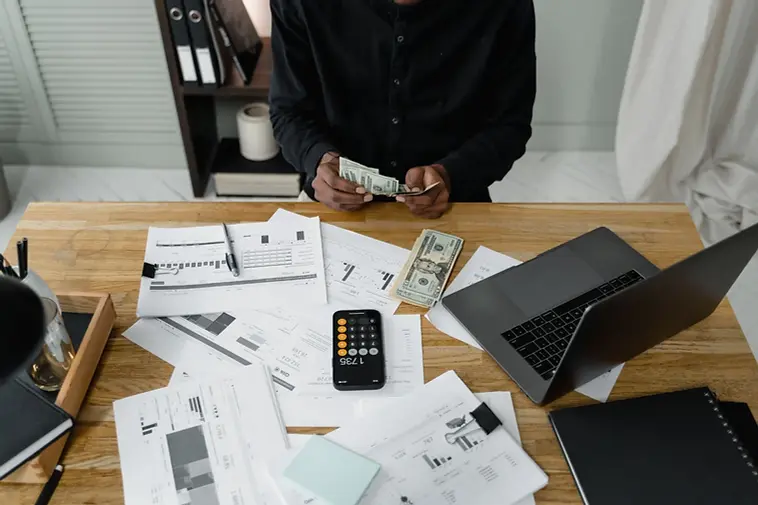 A desk with accounts paperwork, a calculator and a laptop (stock photograph)