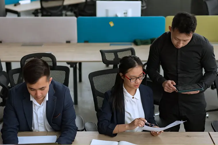 Two people in business dress reviewing documents at a desk (stock photograph)