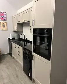 Modern grey fitted kitchen at Lydden Bell Lodge with built-in oven and appliances