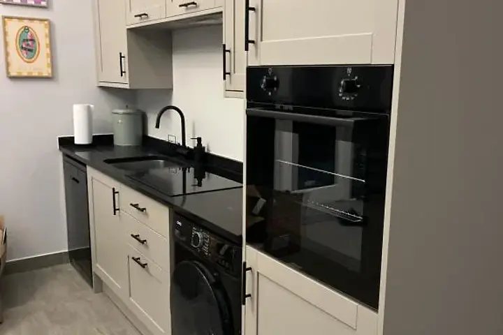 Fitted grey kitchen with oven, hob, dishwasher and washing machine