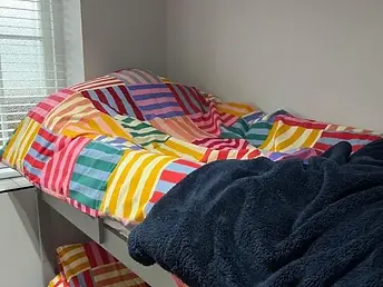 Colourful bunk bed with multicoloured striped bedding at Lydden Bell Lodge in Kent